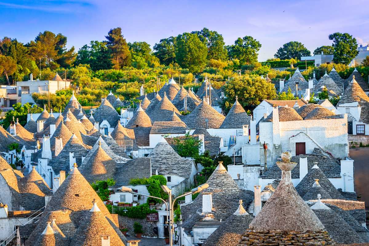 Vista panoramica dal sentiero Monte del Sale, con escursionisti che osservano la Valle d'Itria e i trulli di Alberobello in lontananza